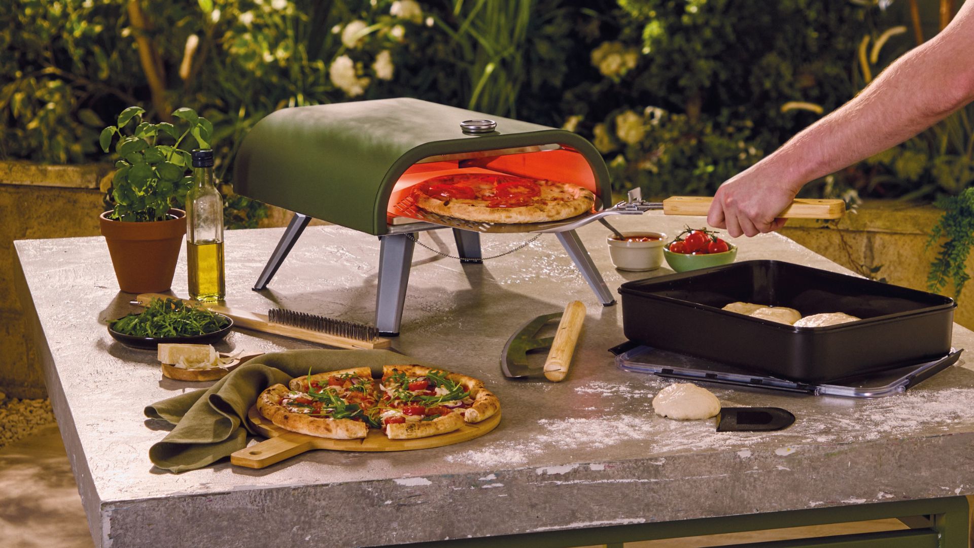 Aldi Pizza Oven on a table cooking pizza, with pizza around it