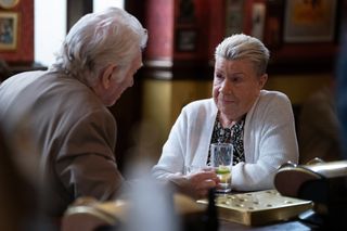 Bi Mo Harris leaning in to talk to Stevie Mitchell at a table in the Queen Victoria pub