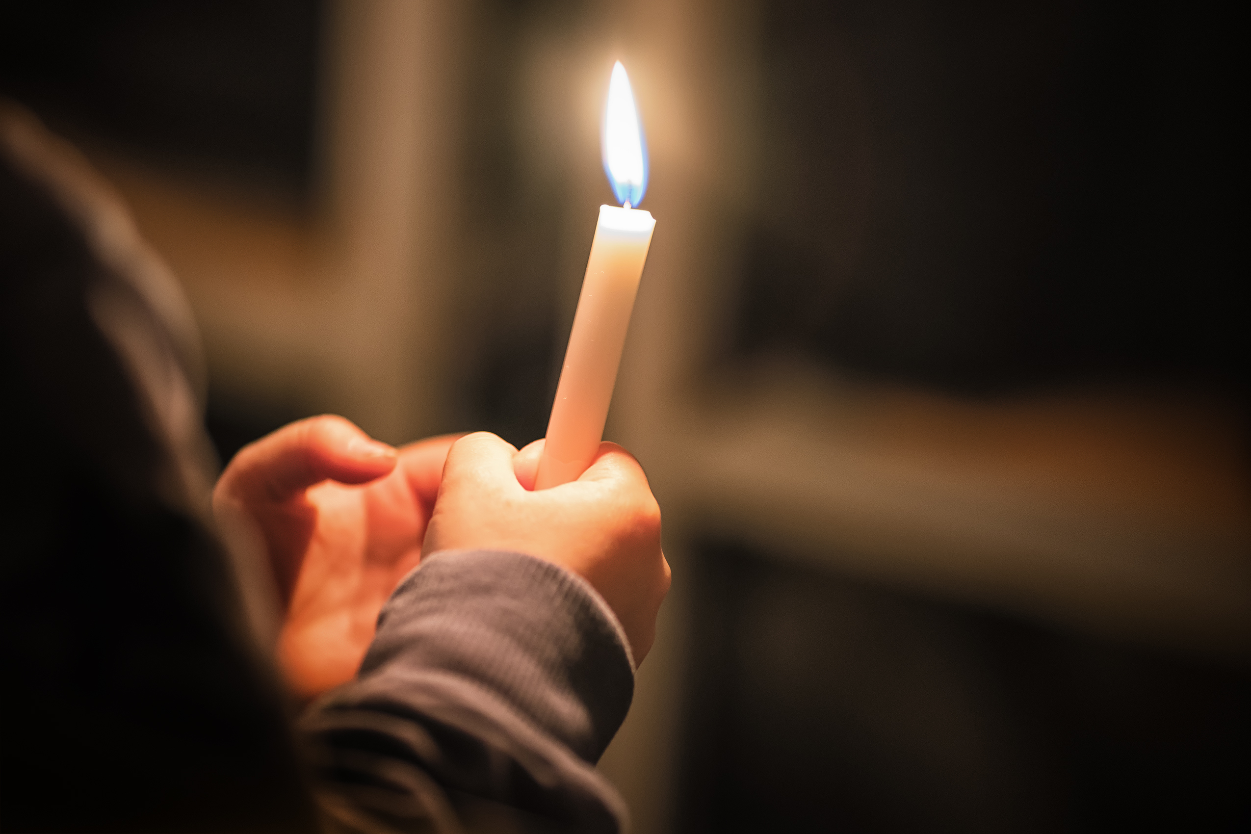 Woman lighting a candle in memory of her mum