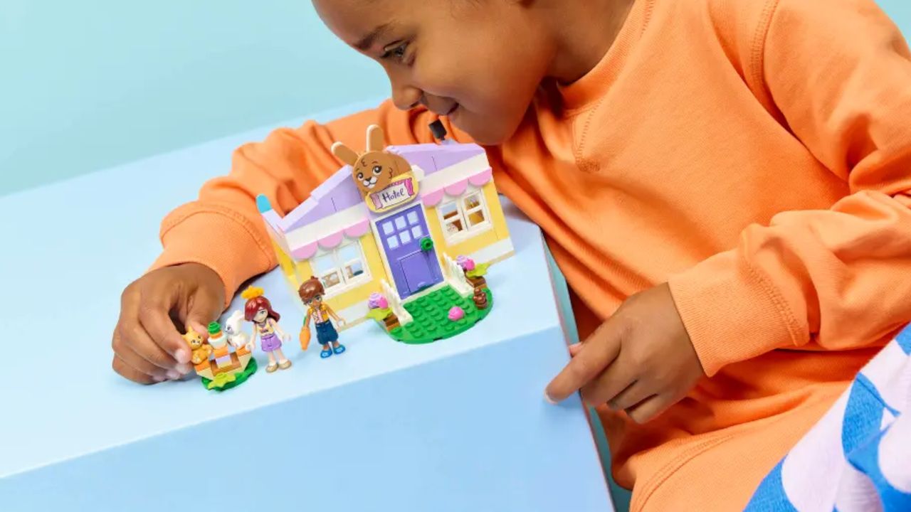 A child plays with a Lego rabbit house set