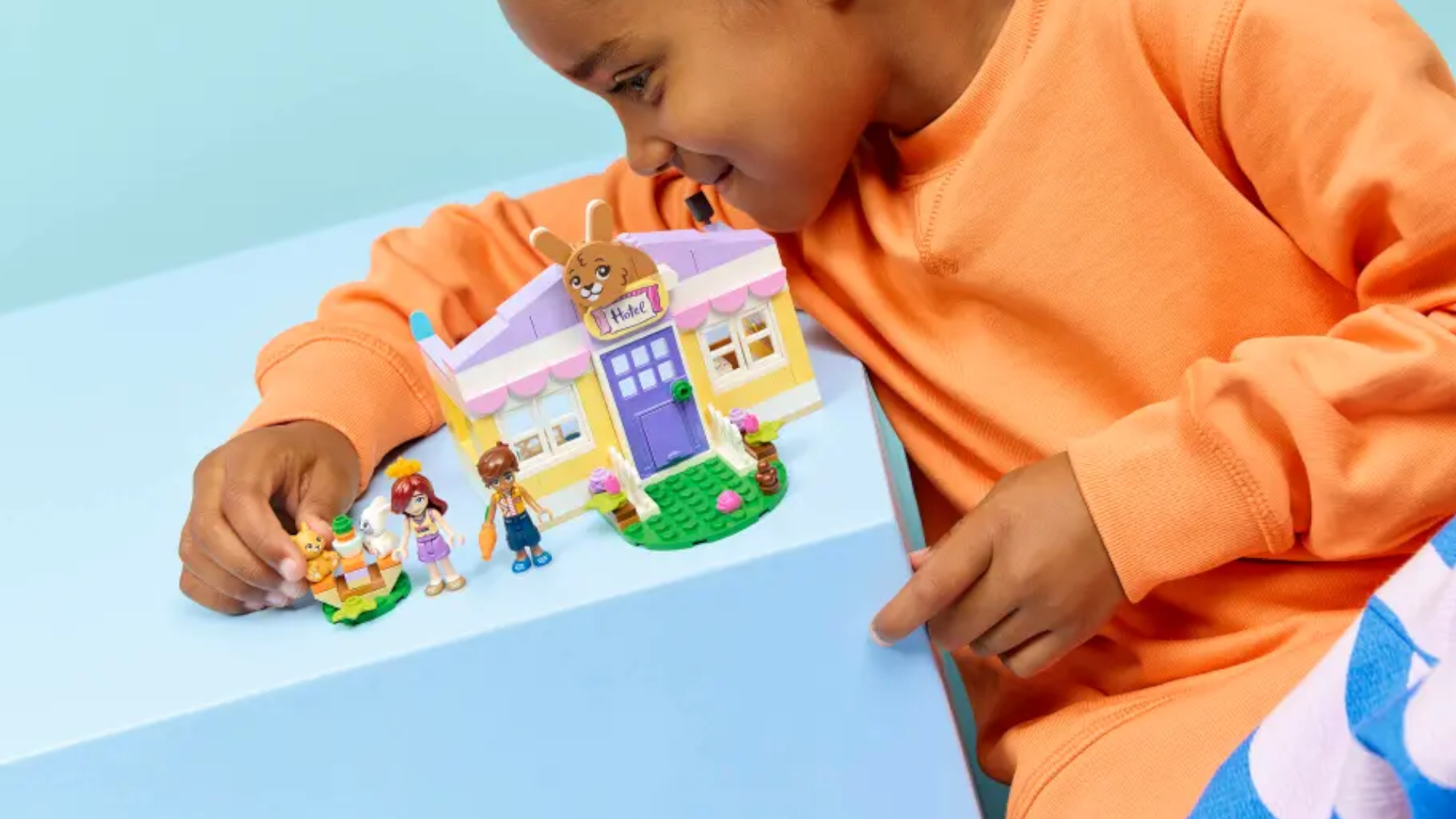 A child plays with a Lego rabbit house set