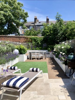 a modern garden with three zones areas for lounging, playing on the grass and dining