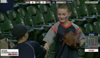 Boy shakes hand of boy who gave him foul baseball.