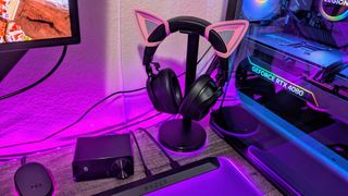 The Razer Kraken V4 Pro on a headset stand with its OLED Control Hub next to it.