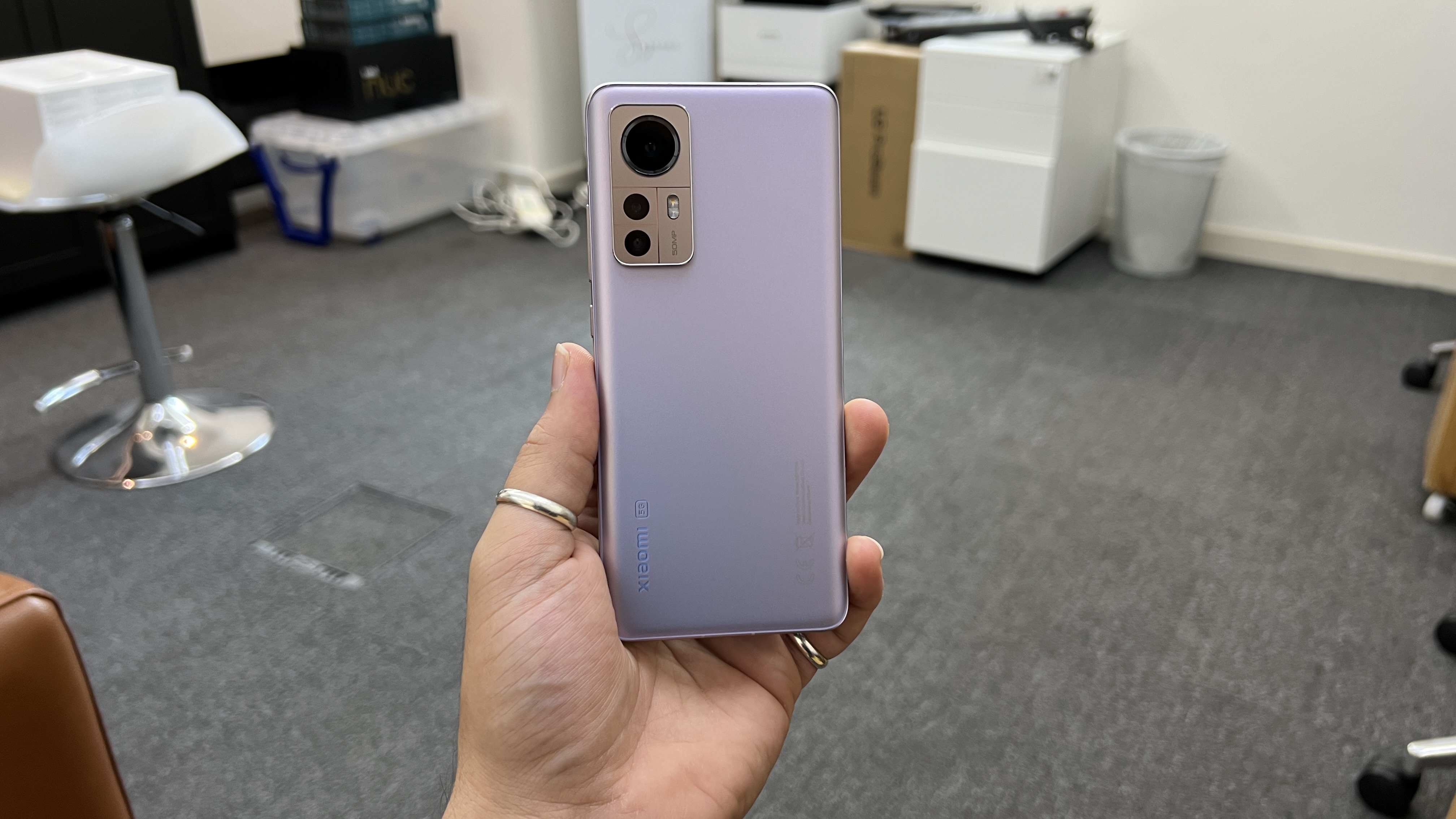 A Xiaomi 12 from the back, in someone's hand