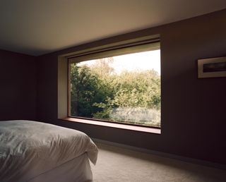 Bedroom with picture window looking out to trees