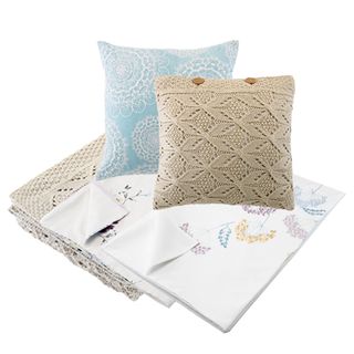 embroidered bedsheets and knitted cushion