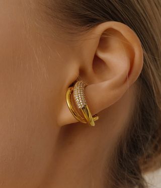 Womans ear wearing a gold and damond hoop