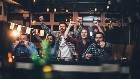 A crowd excitedly watching a TV event