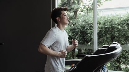 Person wearing a t-shirt running running on a large treadmill