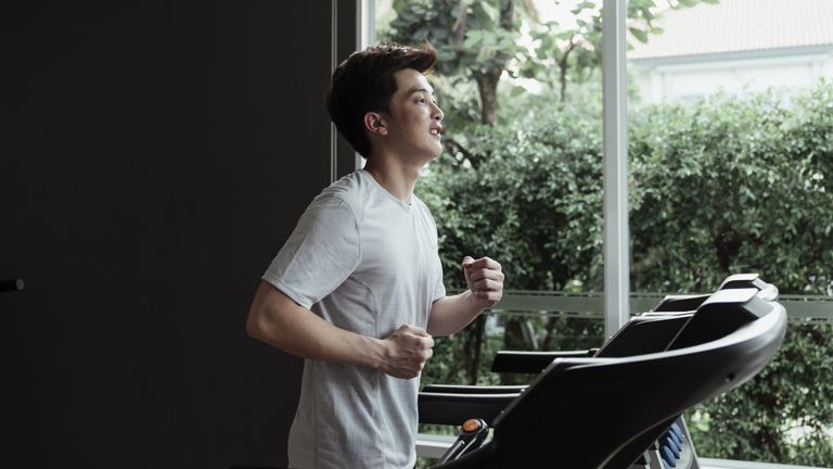Best cheap treadmills: Pistured here, a your man running on a treadmill indoors looking out of a window