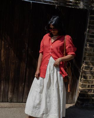 chiarasatelier wears a red linen shirt with a white skirt