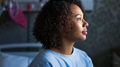 Woman staring into the distance, presumably contemplating taking out private health insurance