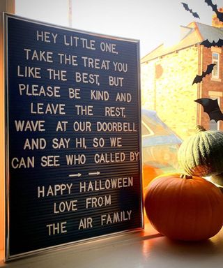 Halloween window decorating idea with message to young trick or treaters explaining instructions on how to receive candy