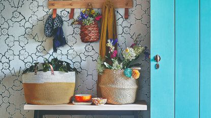 A hallway with a wall-mounted hook rack, a console table and a blue storage closet