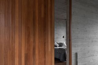 Wood and concrete walls outside bedroom at Belo Horizonte home