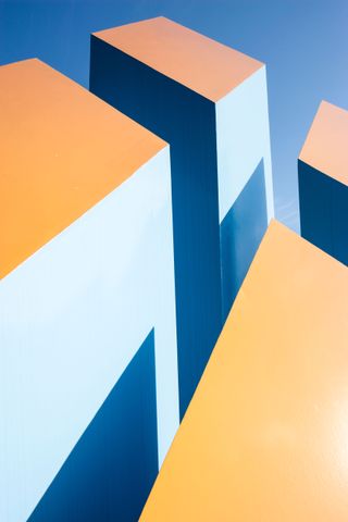 A modern artwork with blue, light blue, and orange geometrical shapes.