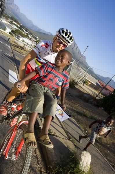 This lucky kid gets a ride on the bars of World Champion Christoph Sauser.
