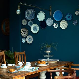 blue walled kitchen with dining table and potted plant