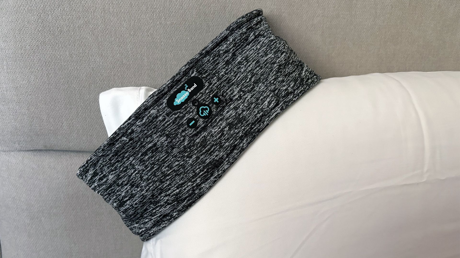 The SnoozeBand balanced on the edge of a pillow in our reviewer's bedroom
