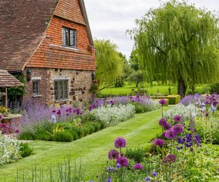 A beautiful traditional country home with manicured lawn and landscape flower beds