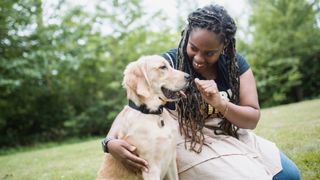 Woman training her Golden Retriever in the park