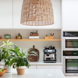 Scandi-style white kitchen with a black sage coffee machine on the counter and a large oversized pendant over an island