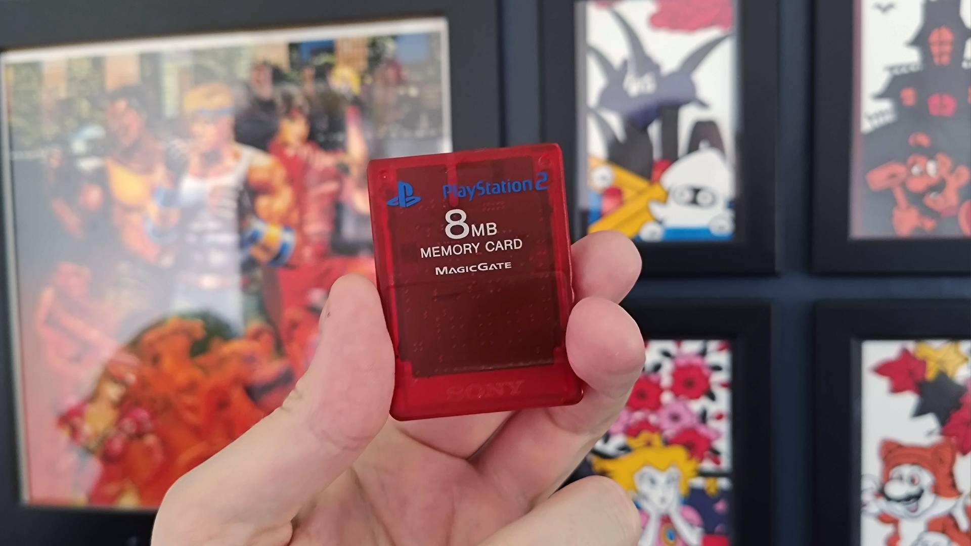 Hand holding transparent red PS2 memory card.