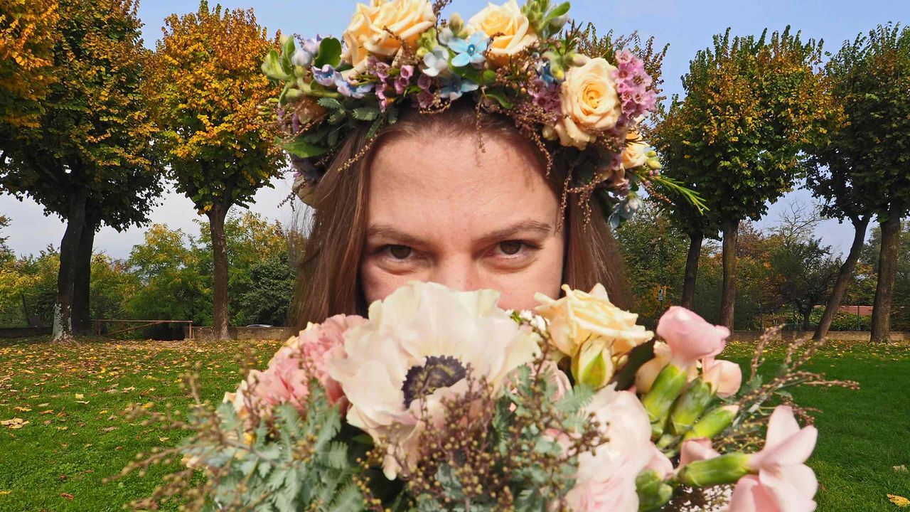  A bridesmaid peeks out from behind her bouquet.