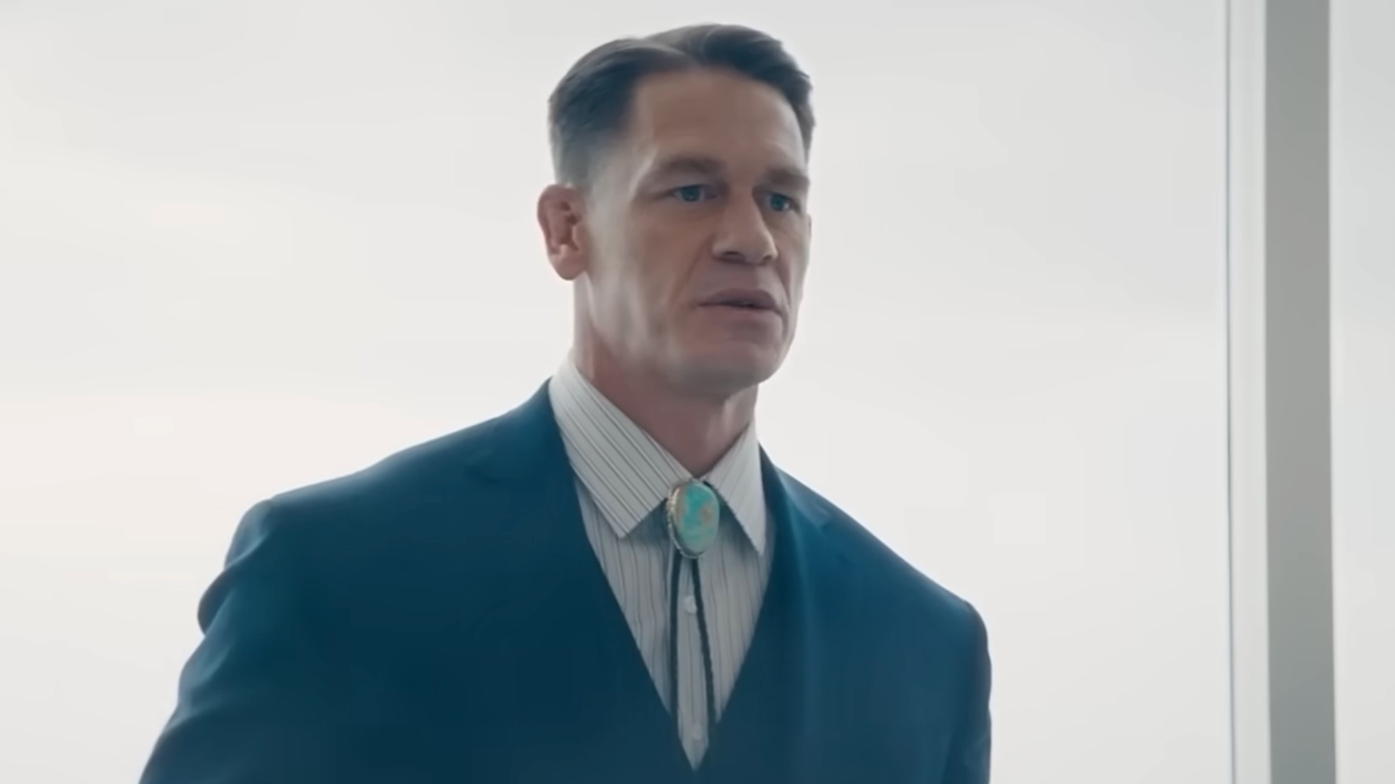 John Cena in his lawyer outfit with a bolo tie. 