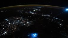 This photo taken from the ISS above the South China Sea on Oct. 30 2021 shows a pair of unrelated bright blue blobs in Earth's atmosphere.