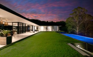 The architectural design features clean minimal lines, emphasized by the single level property and the long edge of the pool following the strong line of the home