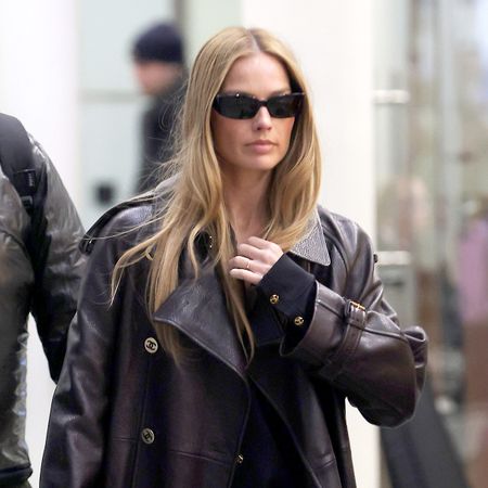 Margot Robbie wearing a Chanel leather trench and track pants at the Eurostar station in Paris