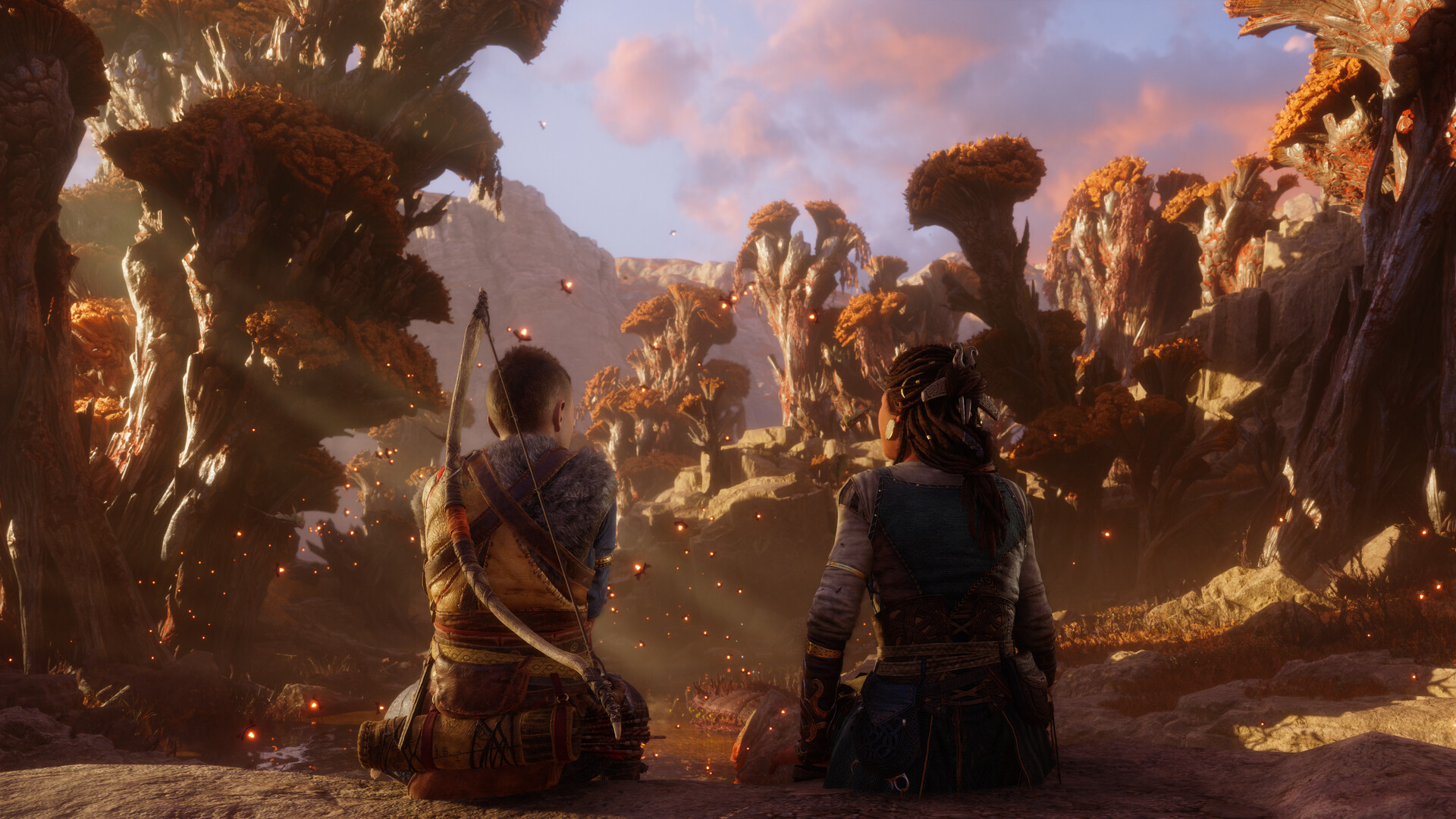 Atreus and Angrboda sit next to one another in a forest in God of War Ragnarok