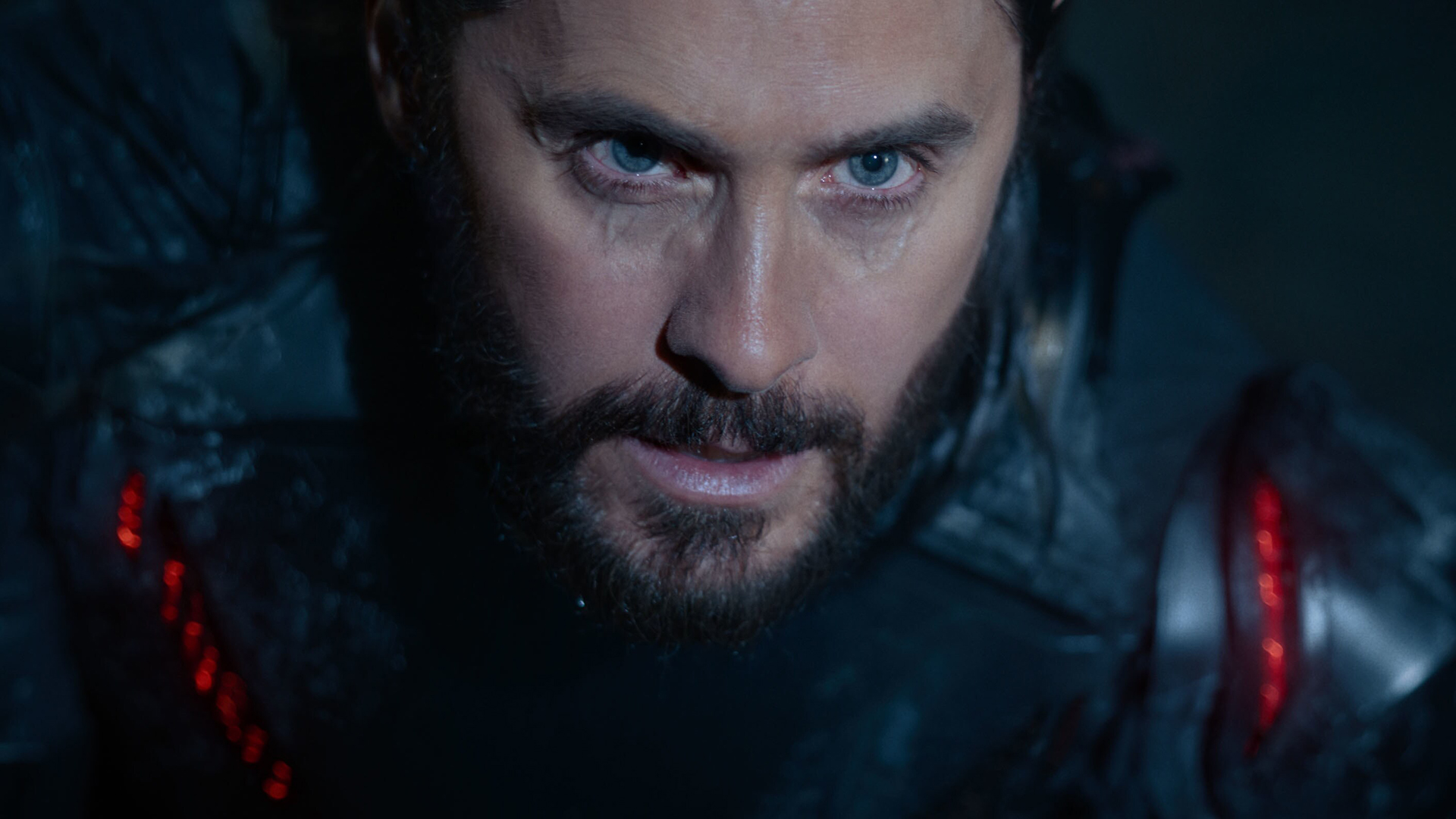 Still from the movie Tron: Ares. Close up of the actor Jared Leto's face who is playing Ares. He is concentrating intensely and dark veins are pulsating around his eyes.