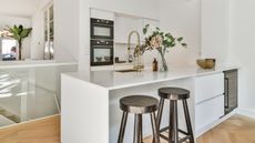 White small kitchen with black bar stools