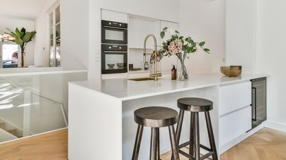 White small kitchen with black bar stools