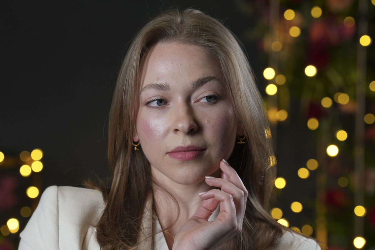 Portraits of a woman in smart jacket, in a studio with blurred fairy lights in background