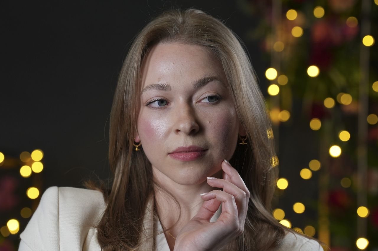 Portraits of a woman in smart jacket, in a studio with blurred fairy lights in background