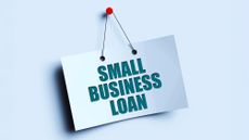 Sign reading 'Small business loan' pinned onto a blue background