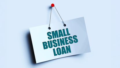 Sign reading 'Small business loan' pinned onto a blue background