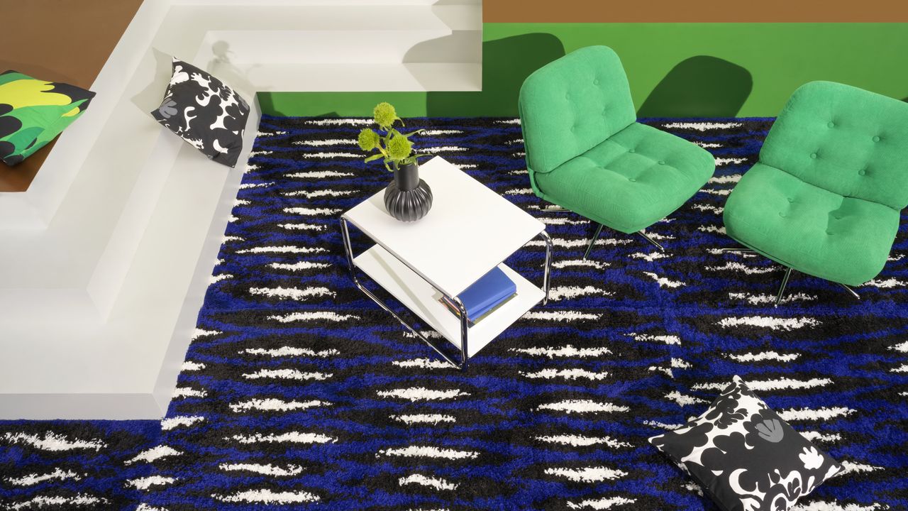 A living room with a black and white rug and retro furniture 