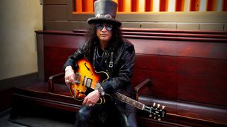 Slash holding his Gibson Custom Shop Slash 1963 Collector's Edition ES-335 guitar