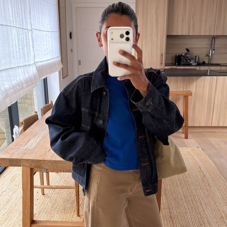 Monikh wears a denim jacket, blue tee, beige jeans.