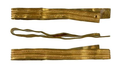 A flattened gold bracelet with intricate detailing