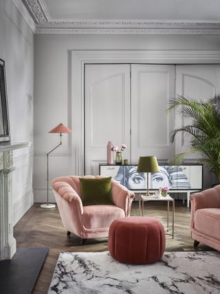velvet pink armchair and red velvet footstool with floorstanding lamp