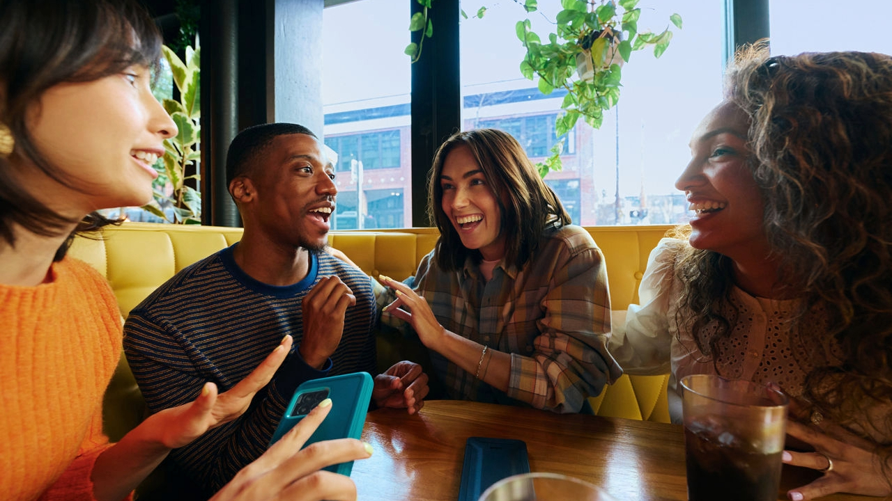 A group of friends laughing and talking in a restaurant