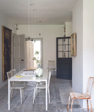 White dining room idea with stone flooring