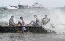 People on a beach in the Philippines during Typhoon Noul.