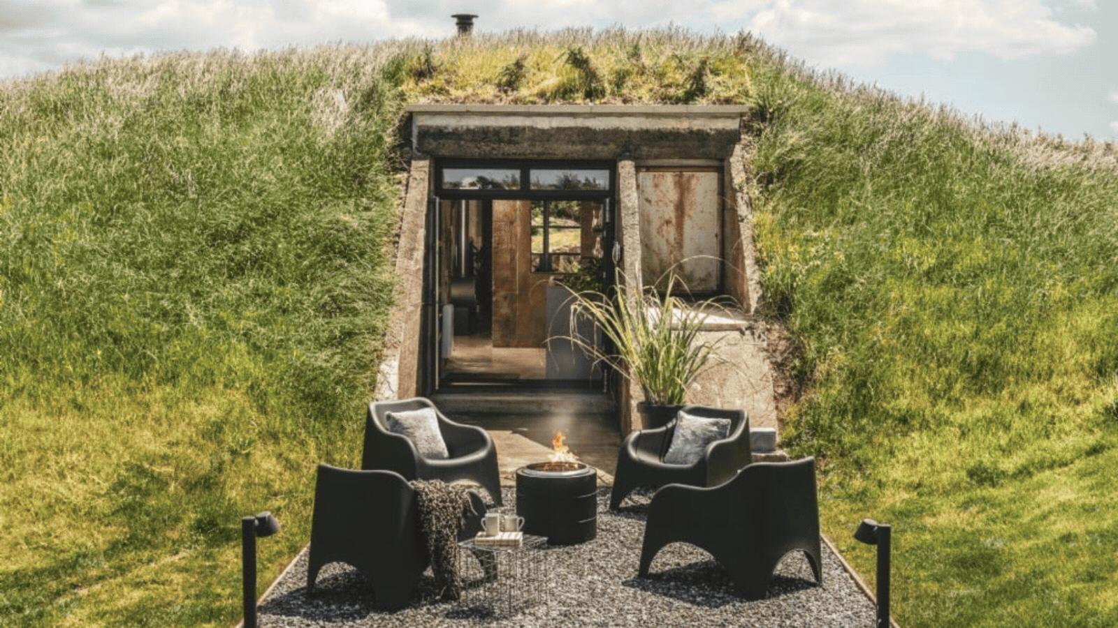 beautiful redesigned concrete war bunker hidden under a grassy mound with modern interiors